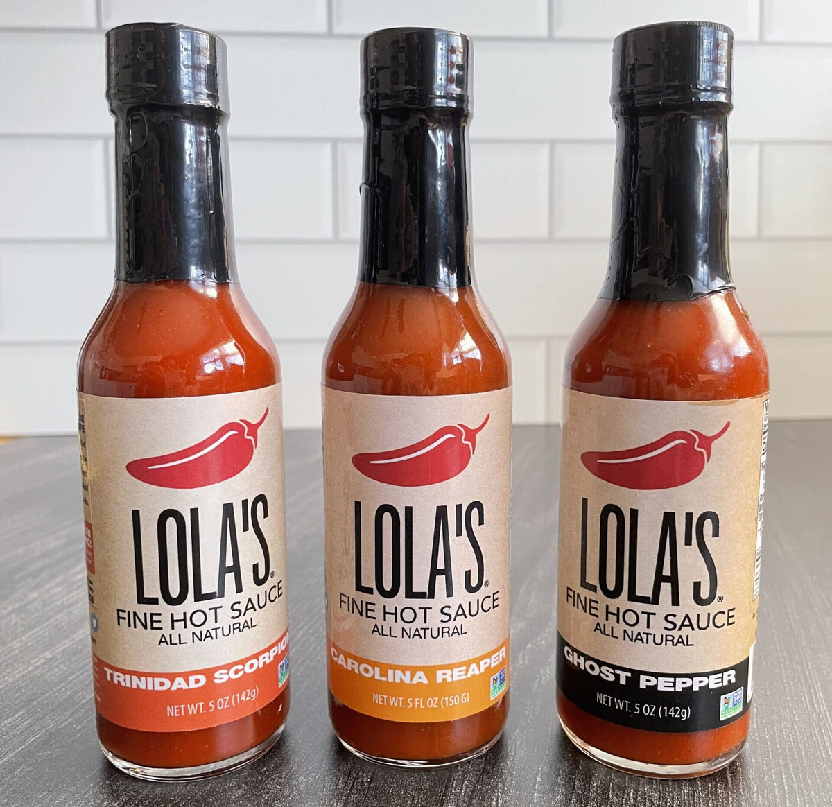 Lola's "Three Hit Wonders" Hot Sauce 3-Pack: Bottles of all-natural, spicy hot sauce - Trinidad Scorpion, Ghost Pepper, and Carolina Reaper.