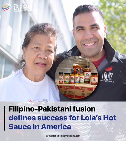A smiling man and woman posing with bottles of hot sauce at Lola's Fine Sauces.