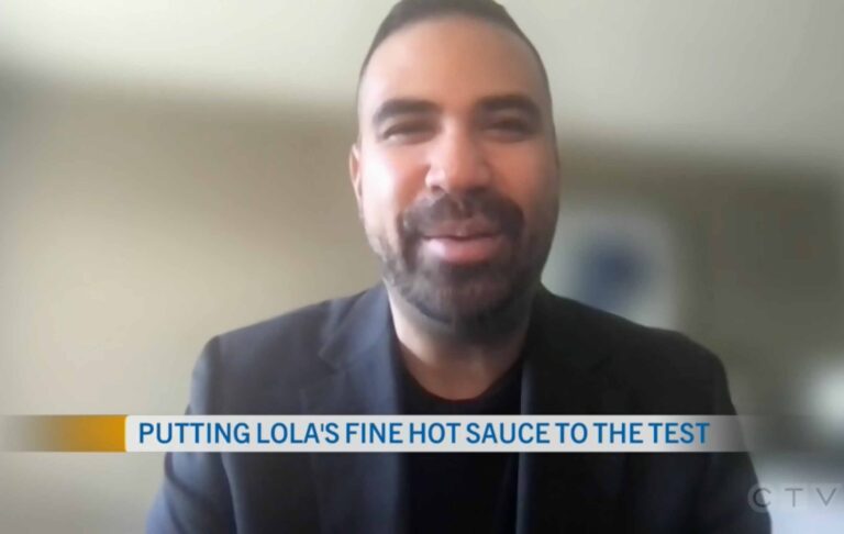 A confident man in a suit with a beard, wearing a black jacket, close-up of his face and mouth, featured in Lola's Fine Sauces article.