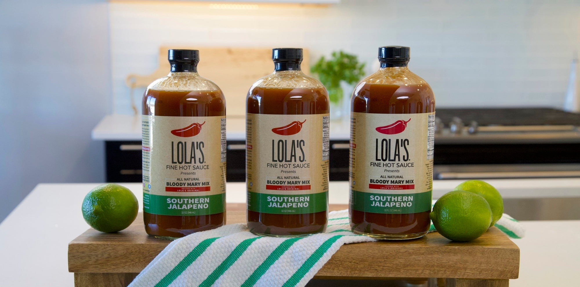 A collection of Bloody Mary Mix bottles from Lola's Fine Sauces. Includes a lime and a jar of food.