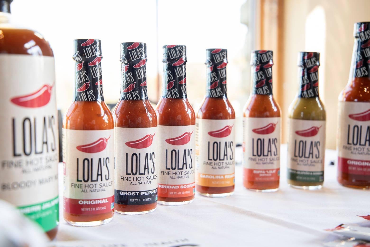 A collection of hot sauce bottles from Lola's Fine Sauces.