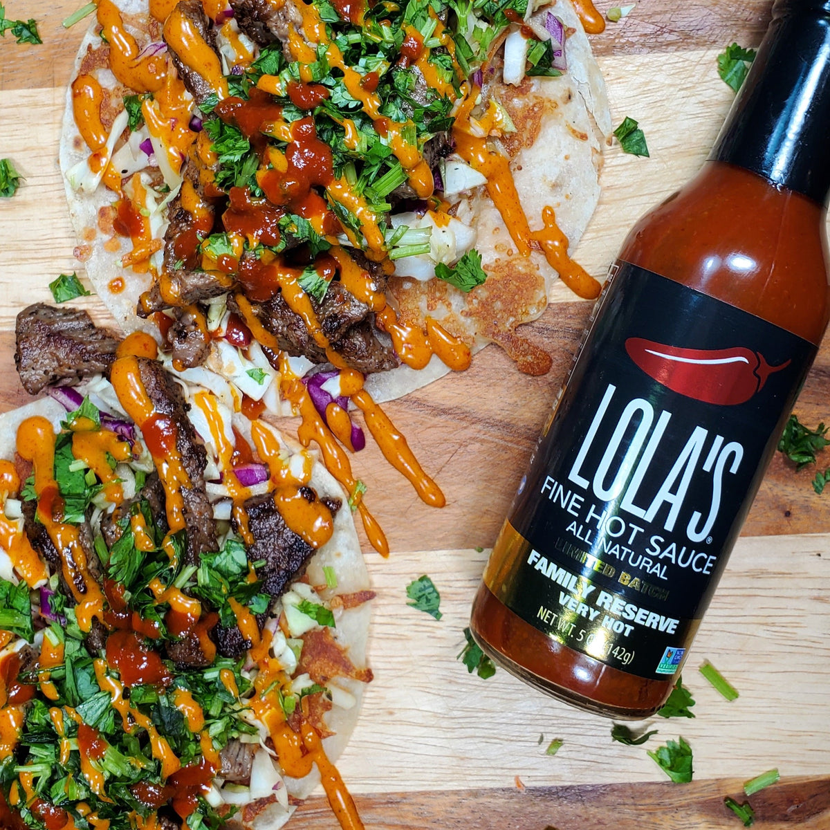 A close-up of Lola's Family Reserve Hot Sauce, a 5 oz. glass bottle with a premium gift box. Crafted with Carolina reaper and habanero peppers, it offers a sweet, smoky, lime flavor with intense heat. 1.8 million+ Scoville rating
