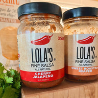 Jars of Lola's Cherry Jalapeño Salsa, a delicious fusion of fresh cherries, hot sauce, and other ingredients, in a 16 oz. glass jar.